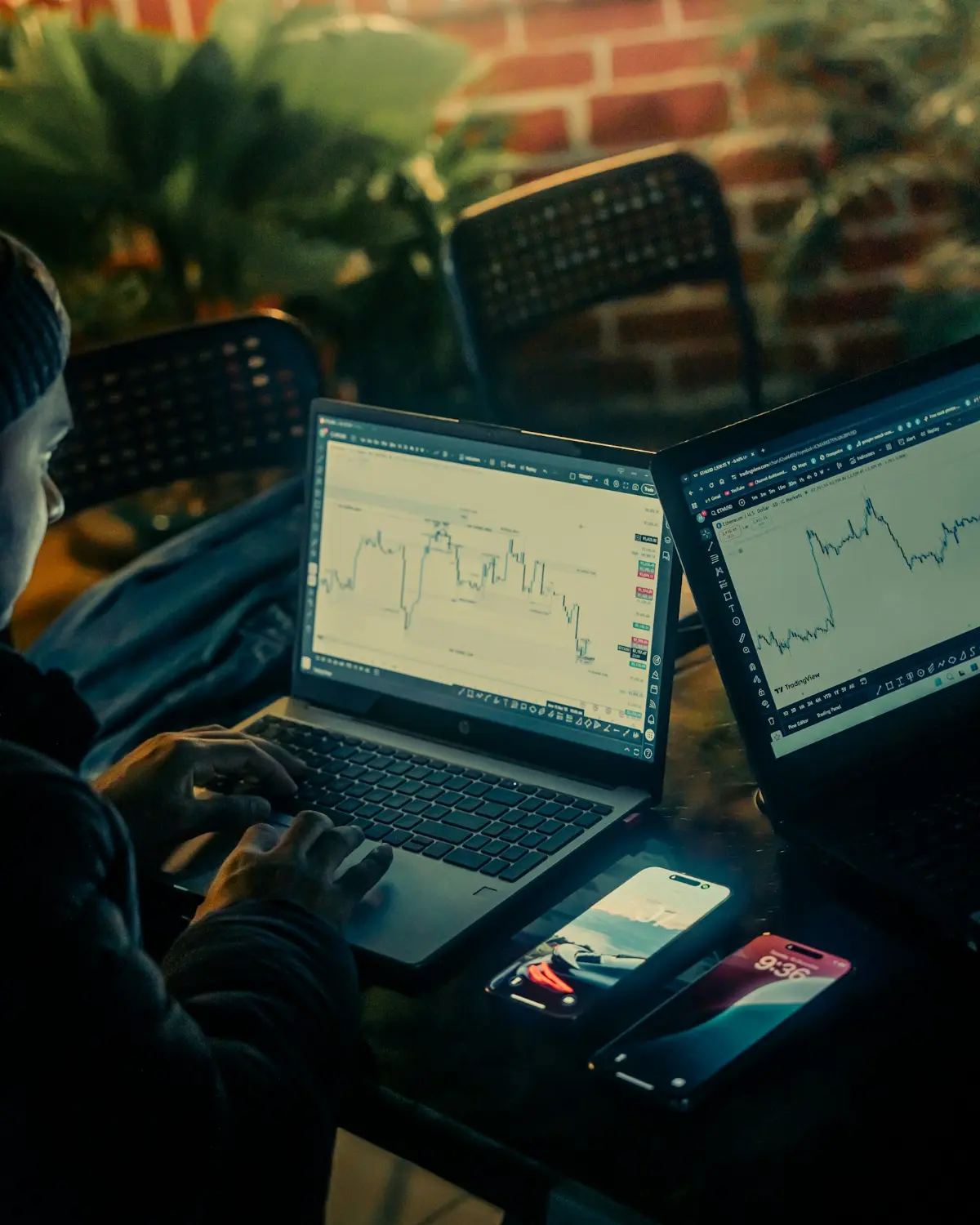 A trader studying live market charts across two screens