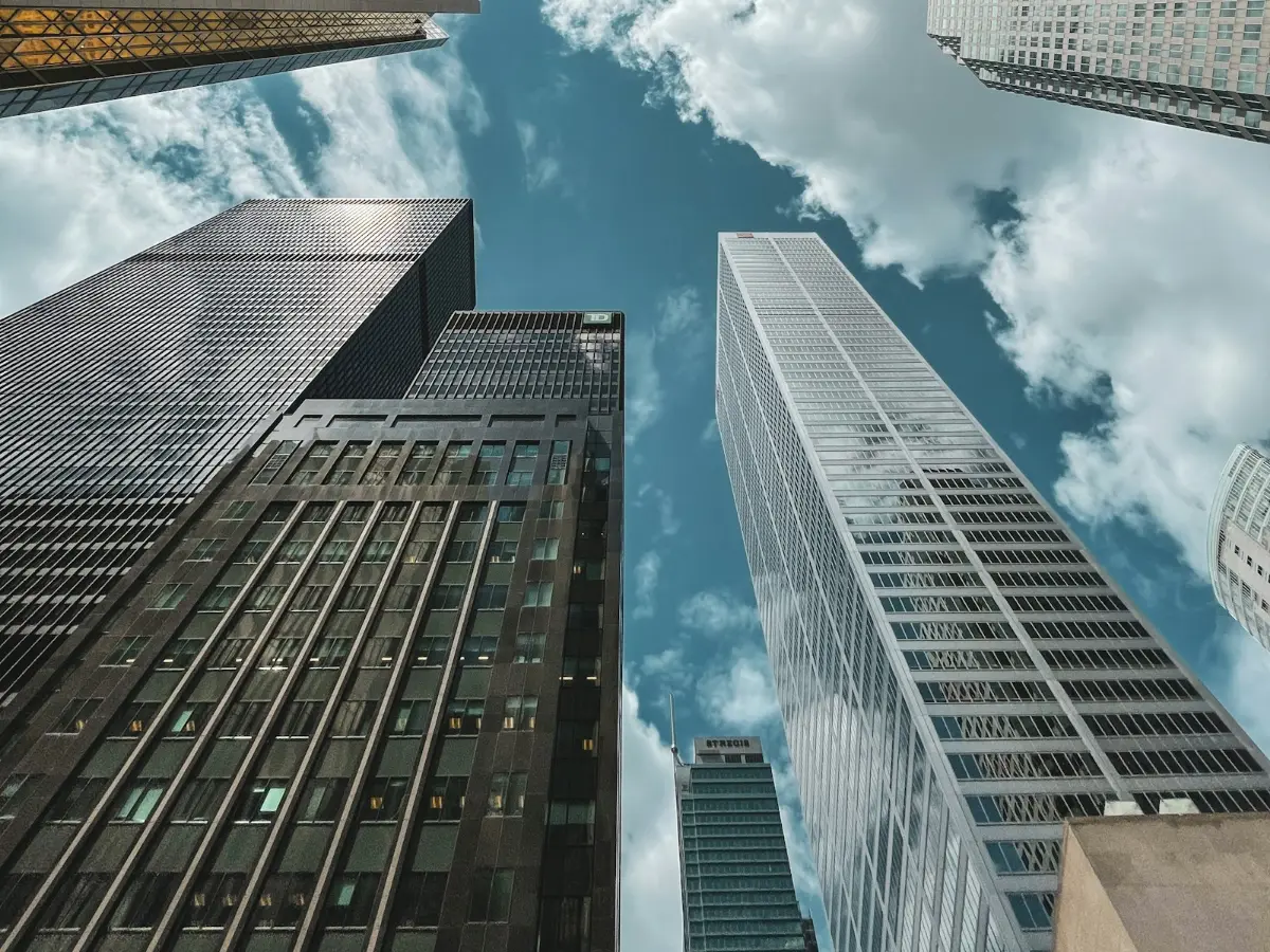 Glass towers rising into a bright blue sky