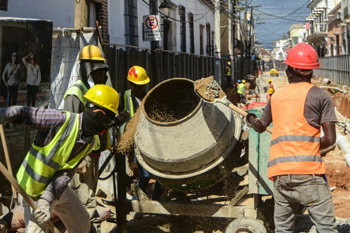 Construction workers operating a cement mixer