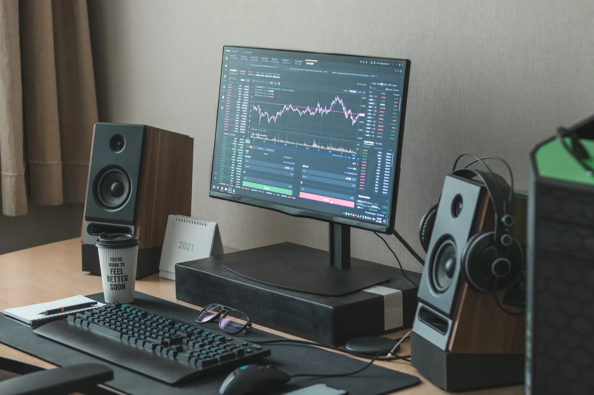 Black flat screen computer monitor turned on beside black computer keyboard