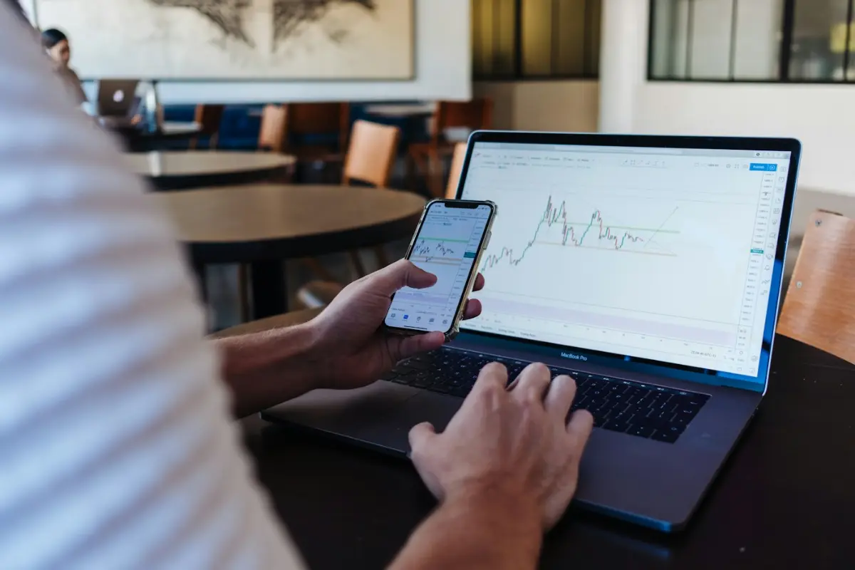 Person using smartphone and MacBook Pro