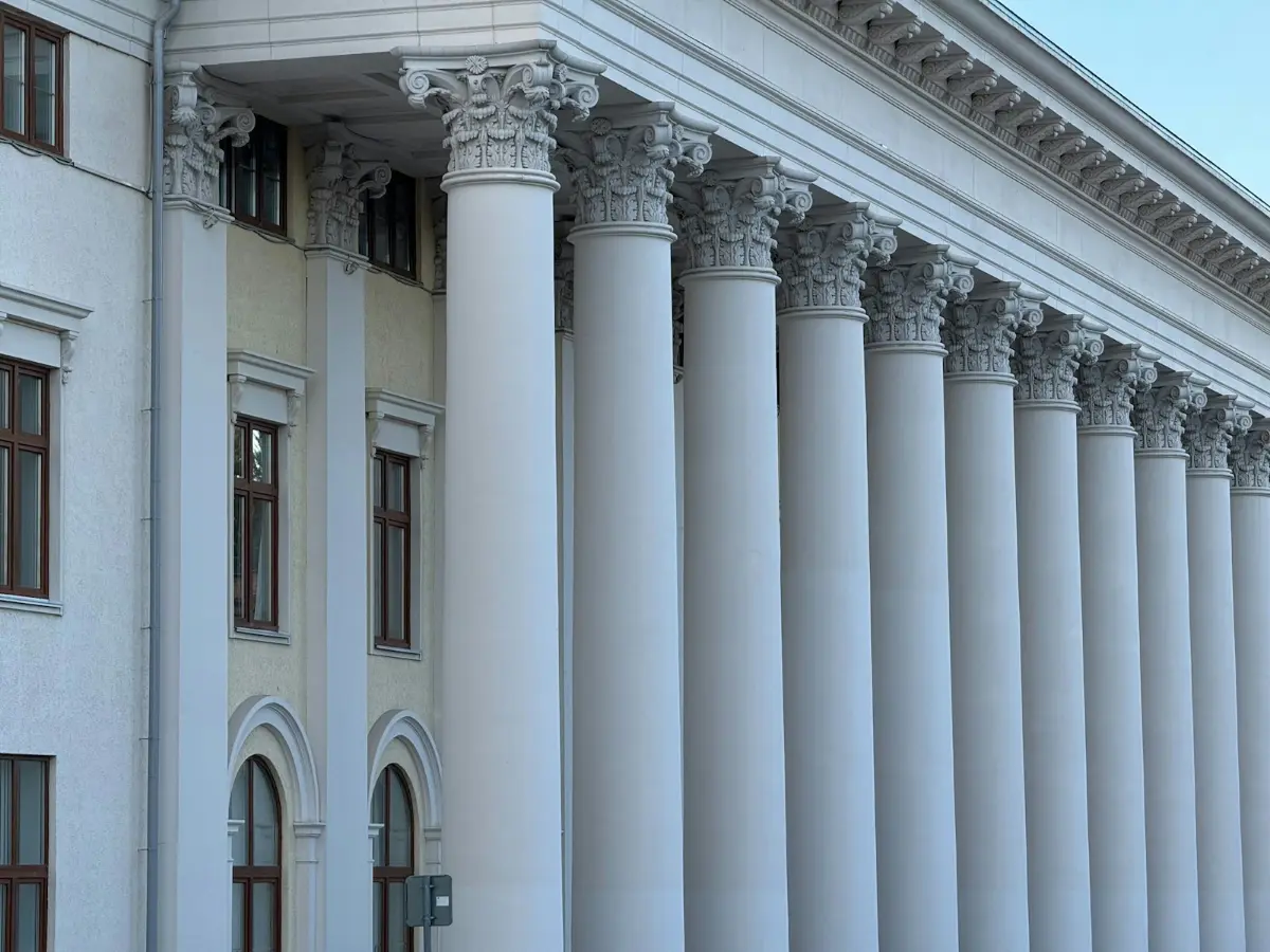 Classical columns of a government building under a bright sky