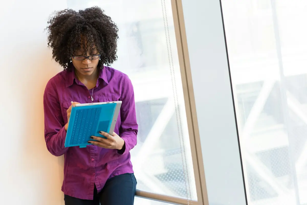 An analyst reading through company research by a bright window