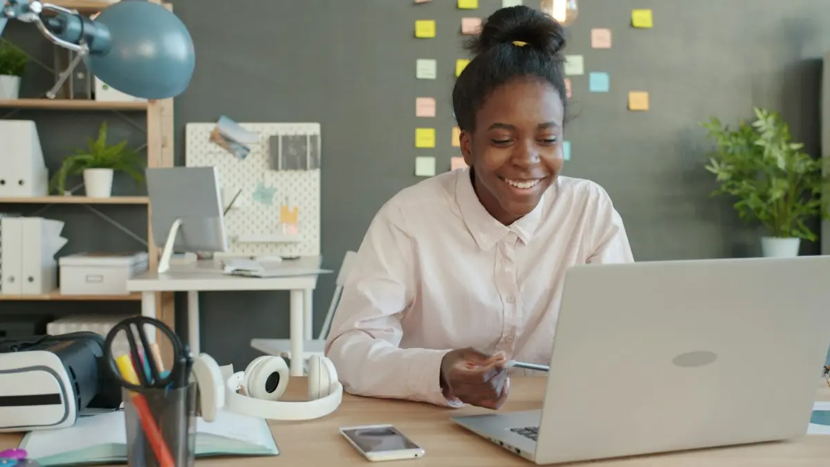 Woman smiling while working on a laptop at a desk