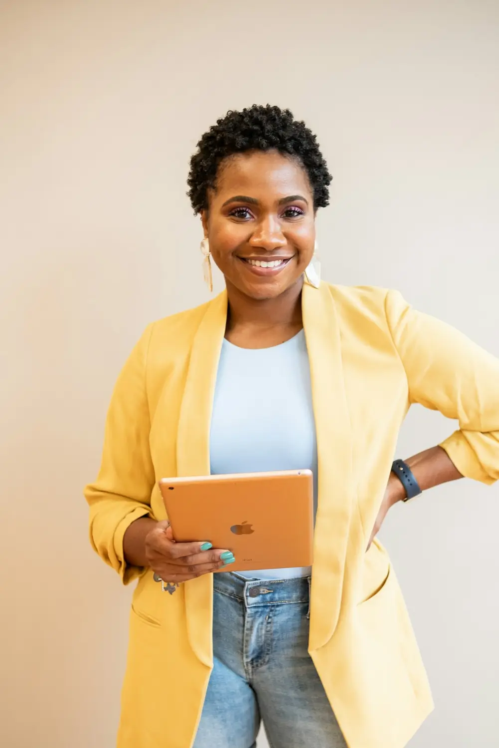 A smiling young professional in a yellow blazer
