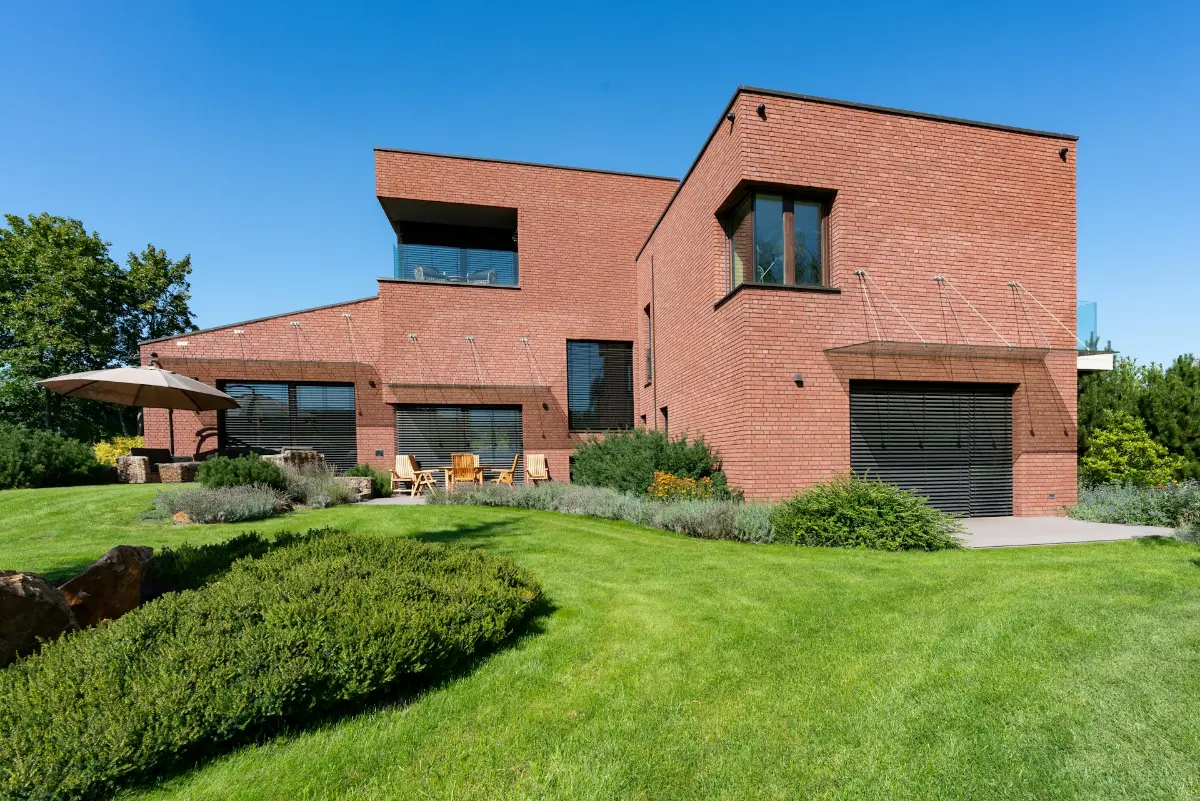 A modern brick villa on a green lawn, illustrative