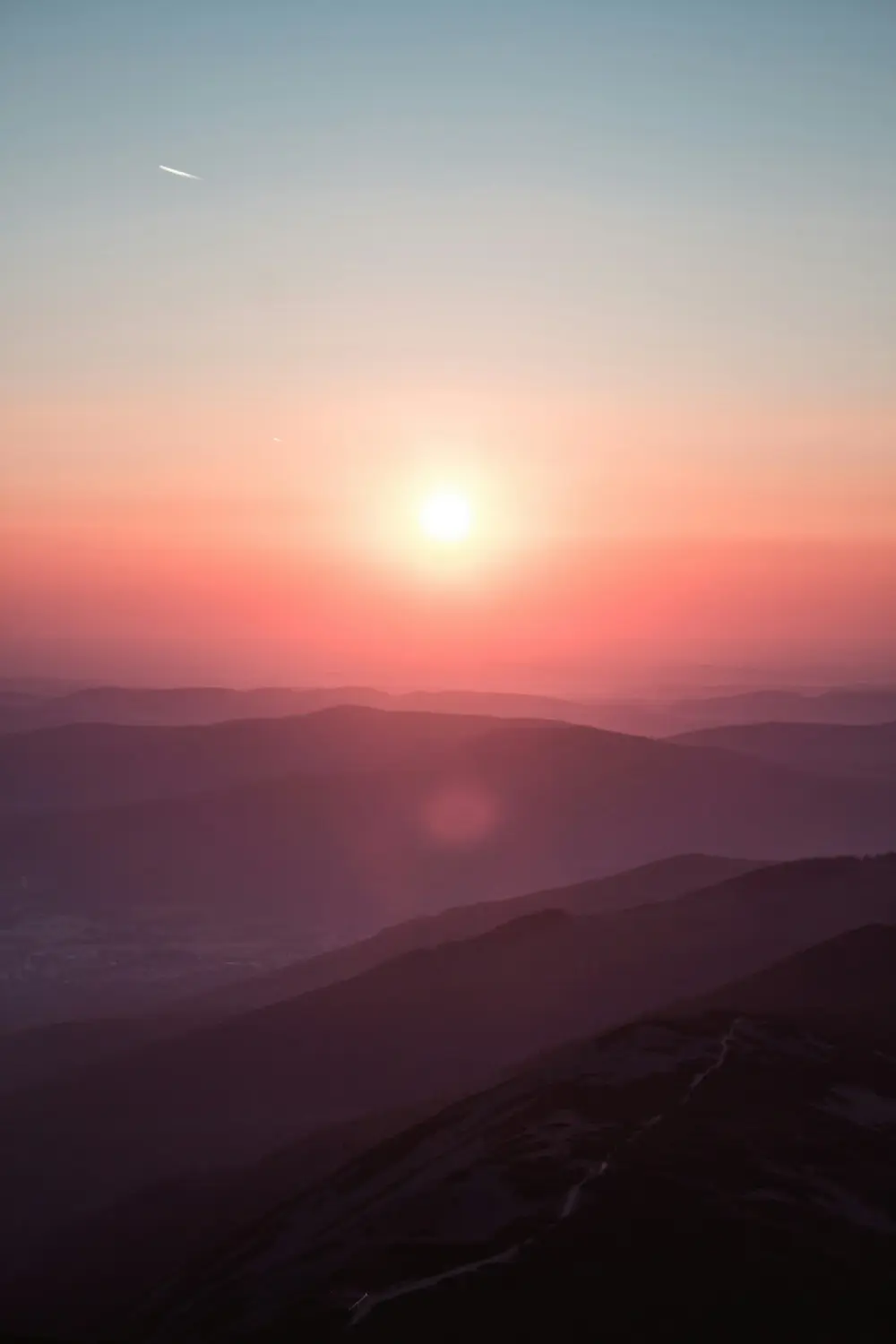 Sunrise over layered mountain ridges
