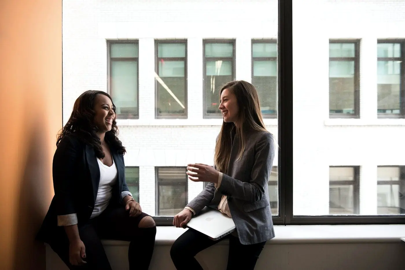 Two colleagues talking by a window